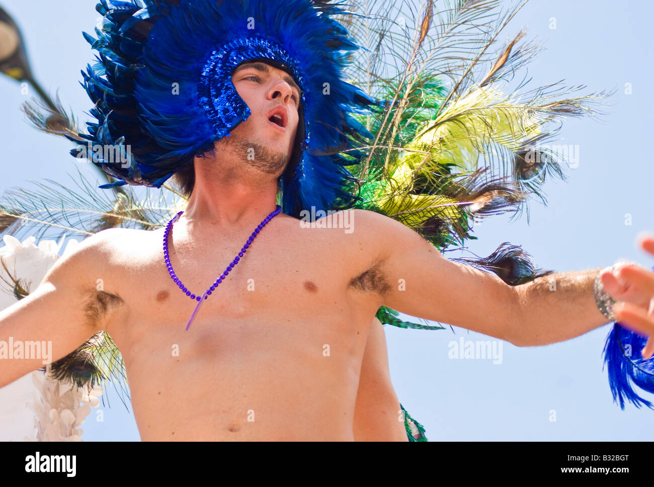 Young man wearing a carnivale head dress dances on a float in the Chicago Gay Pride Parade Stock Photo