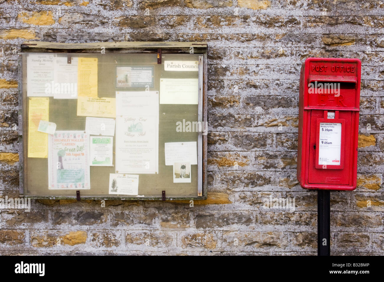 Traditional British postbox with Parish Council notice board Stock Photo