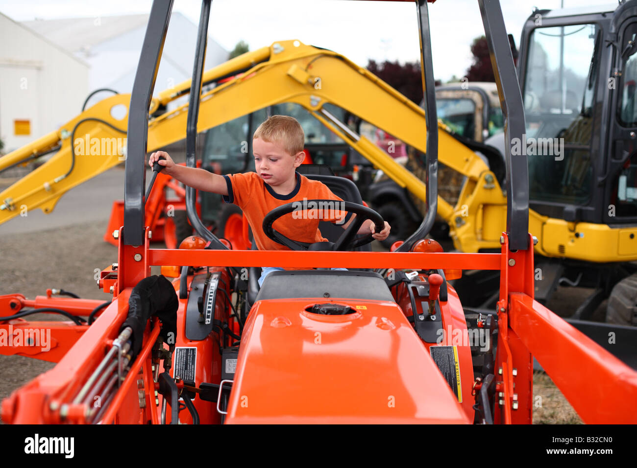 Young boy playing on tractor Stock Photo Alamy