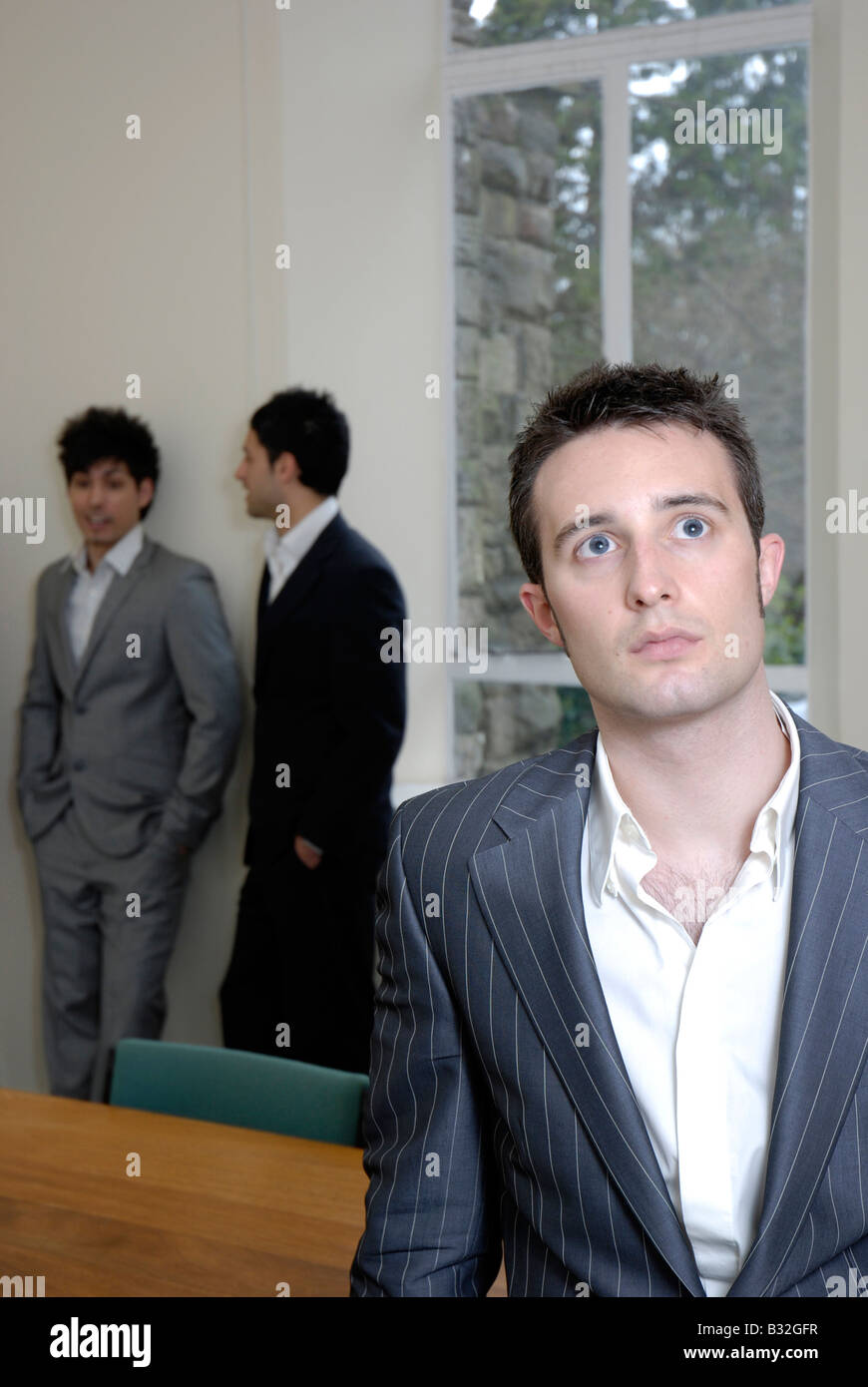 A young business man looking upwards with a thoughtful imaginative expression Stock Photo