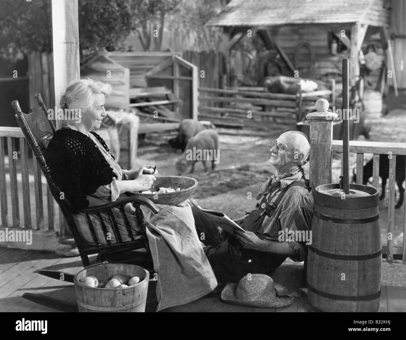 Elderly couple on porch of farmhouse Stock Photo
