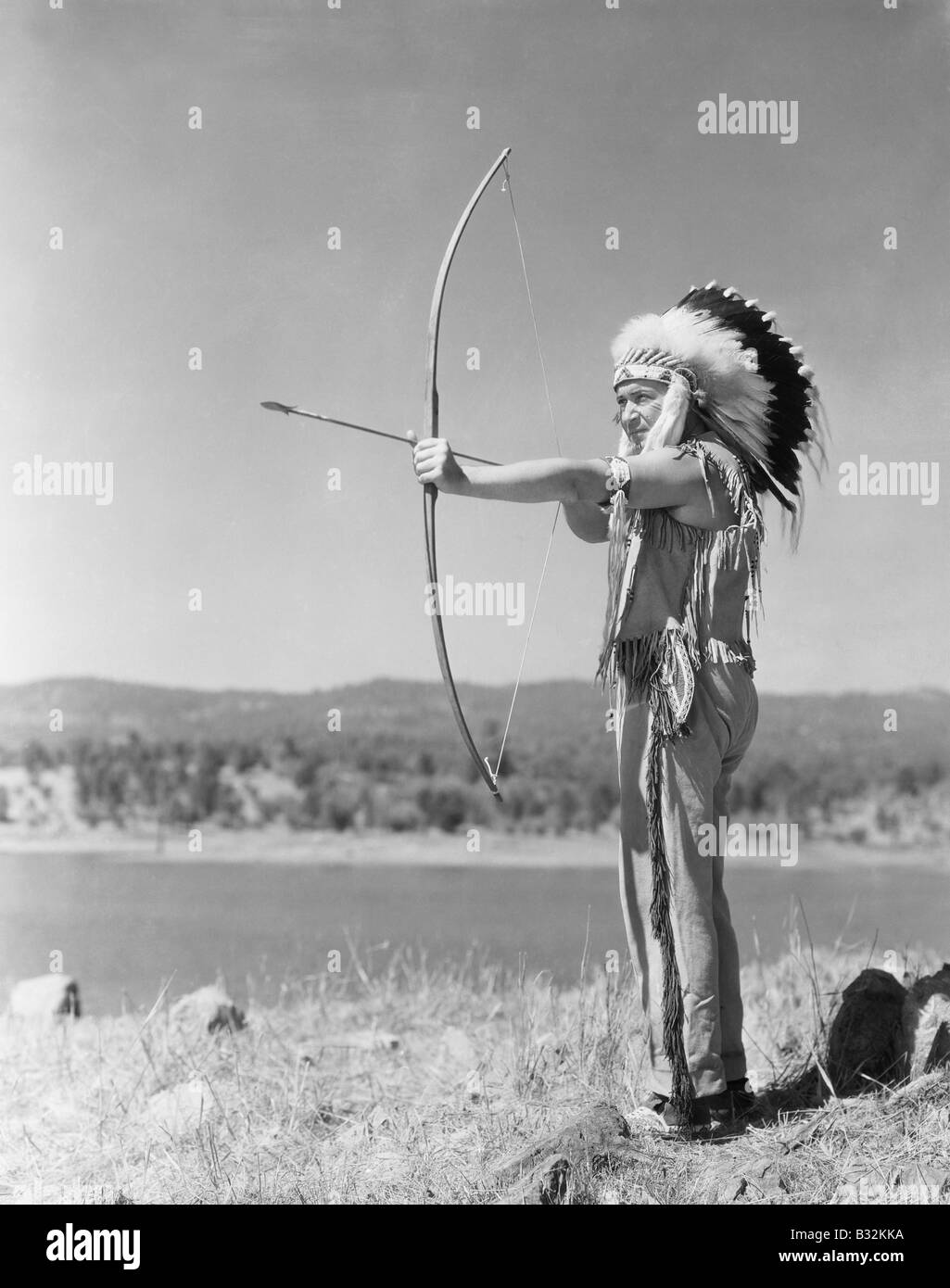 Man shooting with bow and arrow Stock Photo