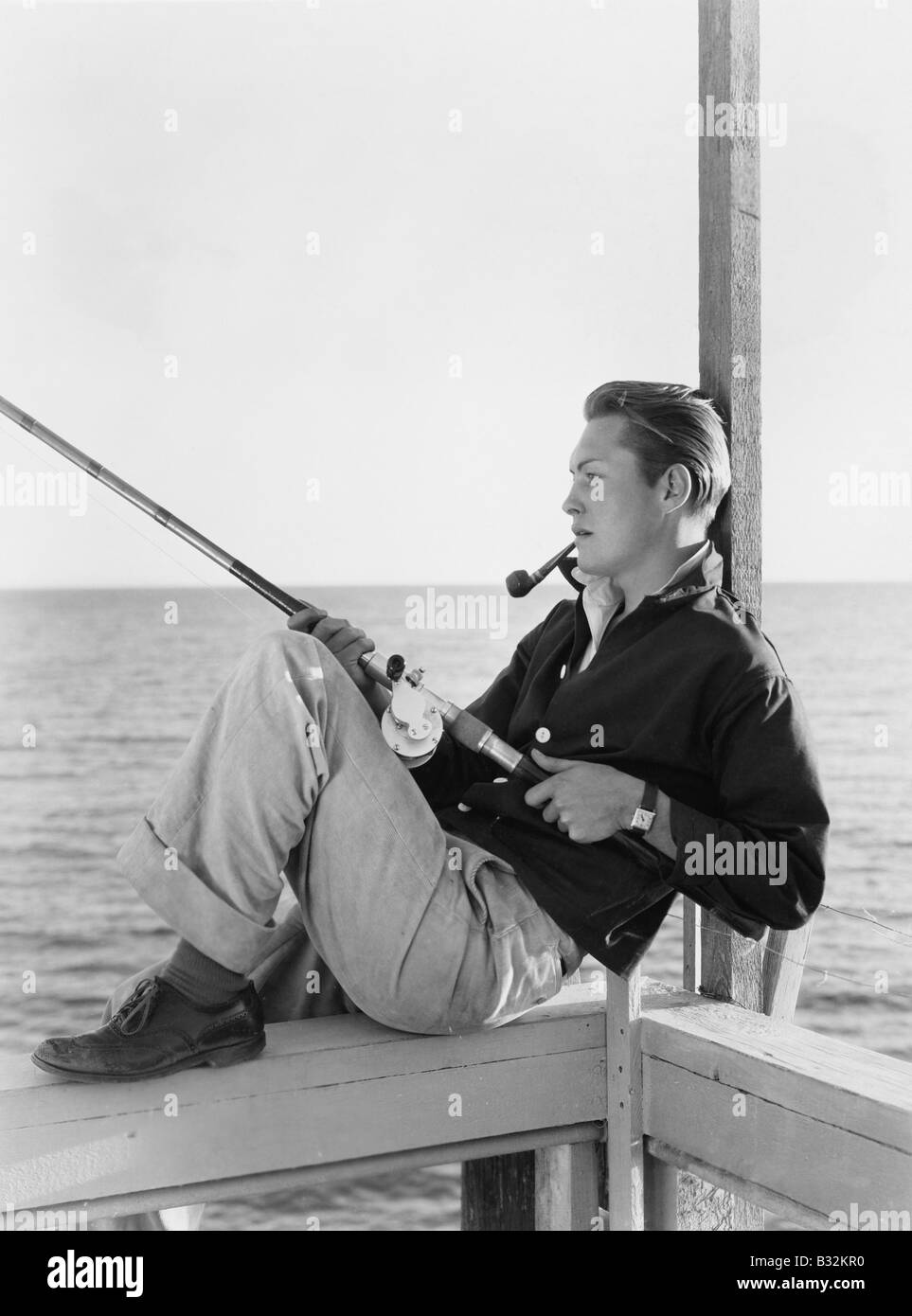 Man fishing and smoking pipe Stock Photo - Alamy