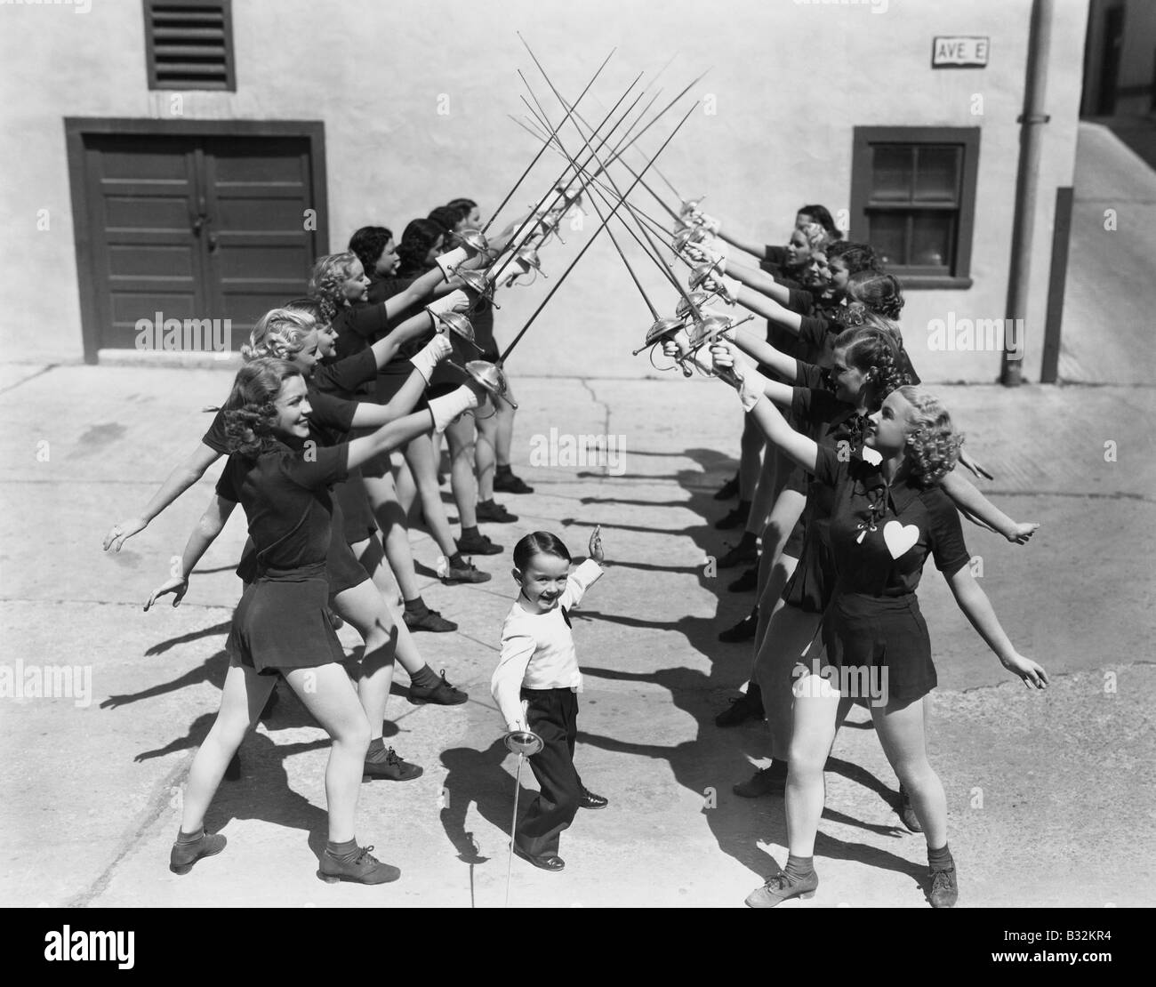 Teenage girls and little boy fencing Stock Photo