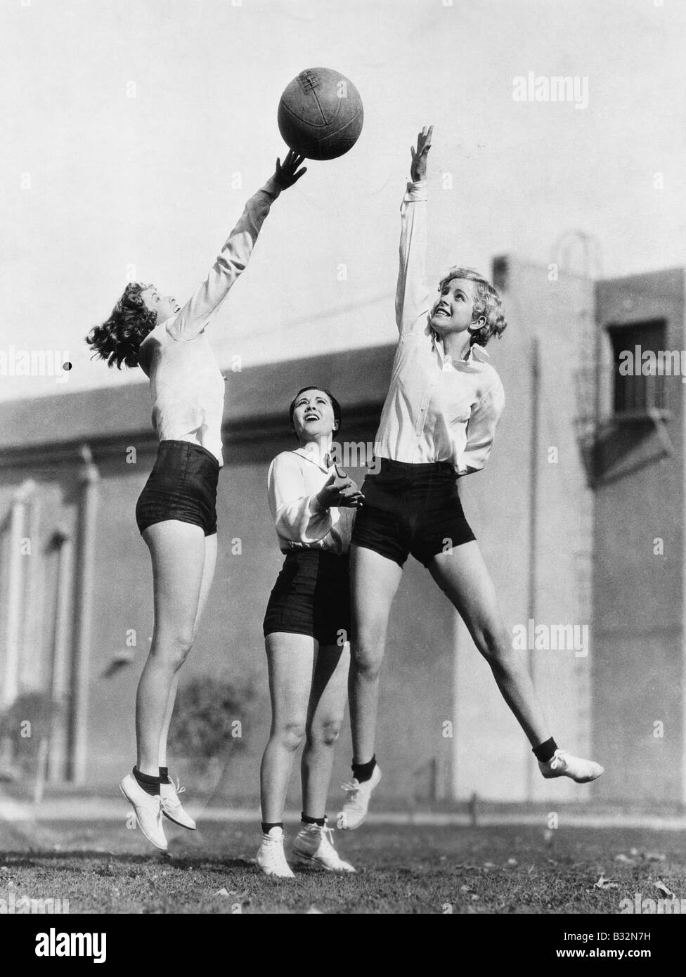 Three women with basketball in the air Stock Photo