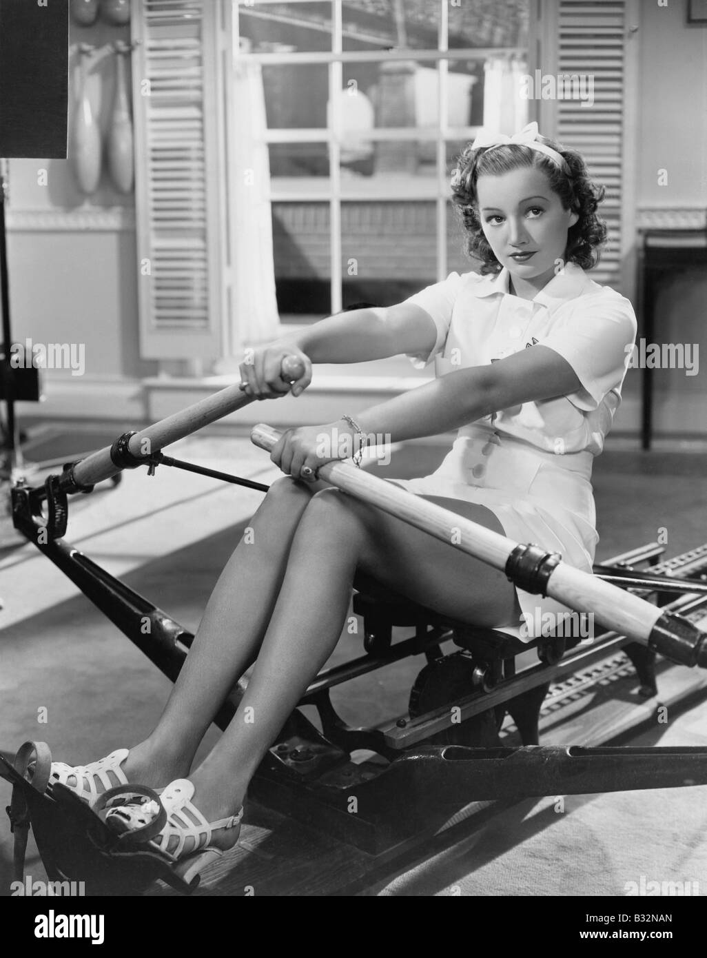 Woman using rowing machine Stock Photo