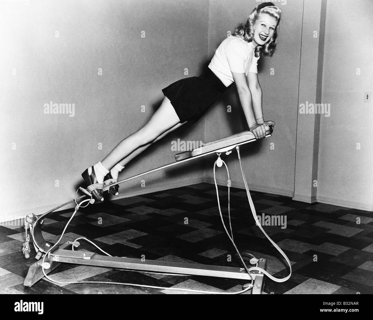 Woman using exercise equipment Stock Photo
