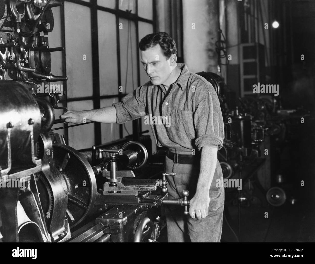 Serious man using large machine Stock Photo