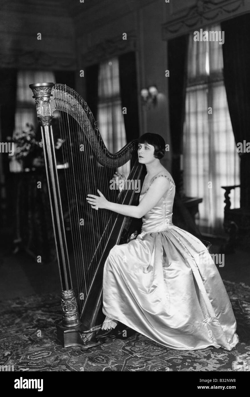 Woman playing harp hi-res stock photography and images - Alamy