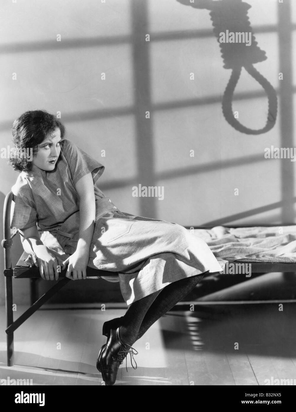 Female prisoner with shadow of noose Stock Photo