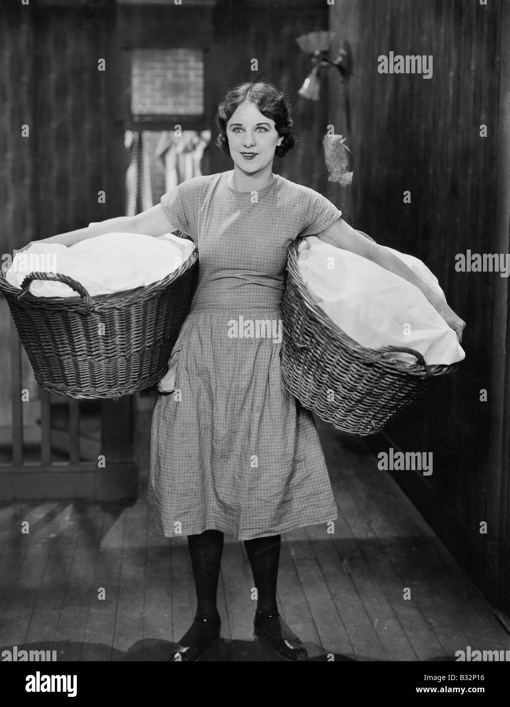 Woman carrying laundry baskets Stock Photo