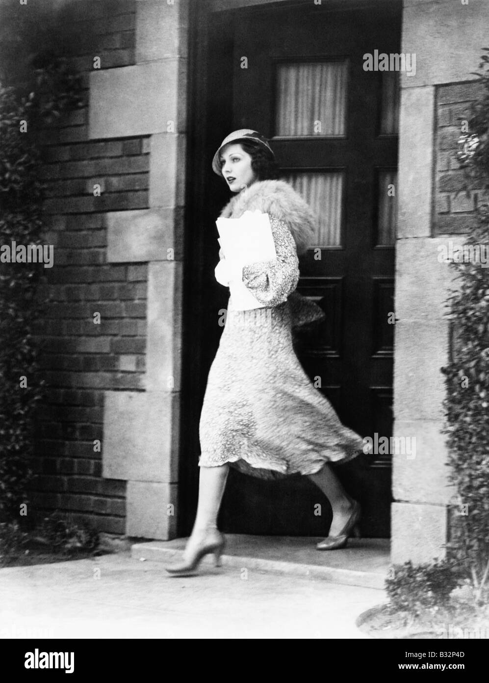 Young woman walking out door Stock Photo