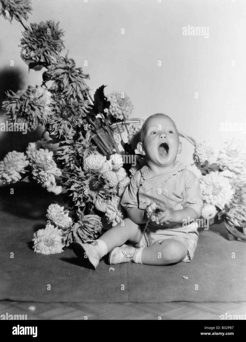 Baby with bouquet of flowers Stock Photo
