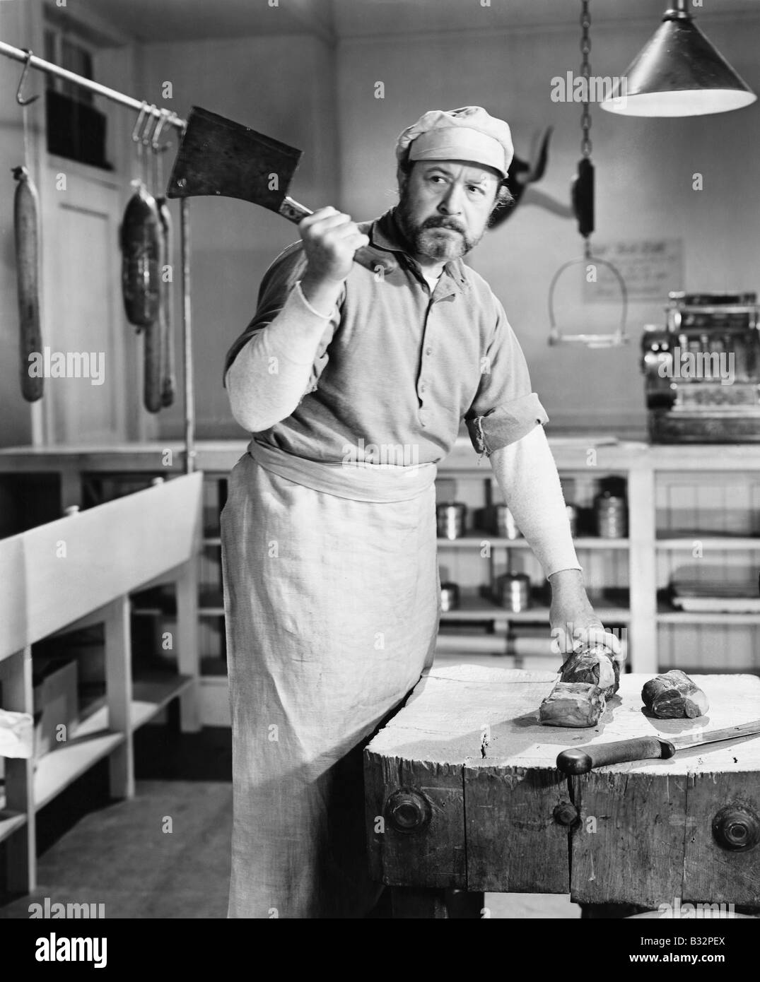 Butcher chopping meat with cleaver Stock Photo