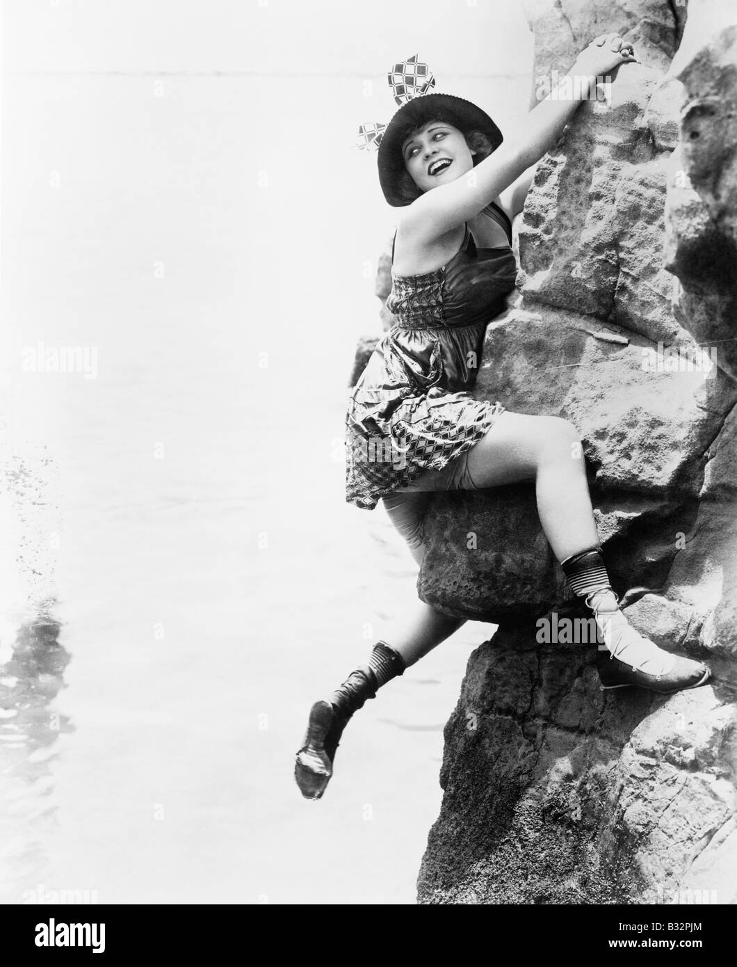 Portrait of woman climbing rock cliff Stock Photo