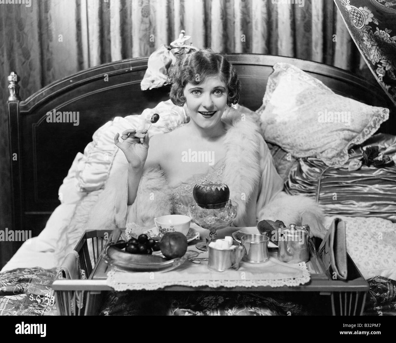 Woman eating breakfast in bed Stock Photo