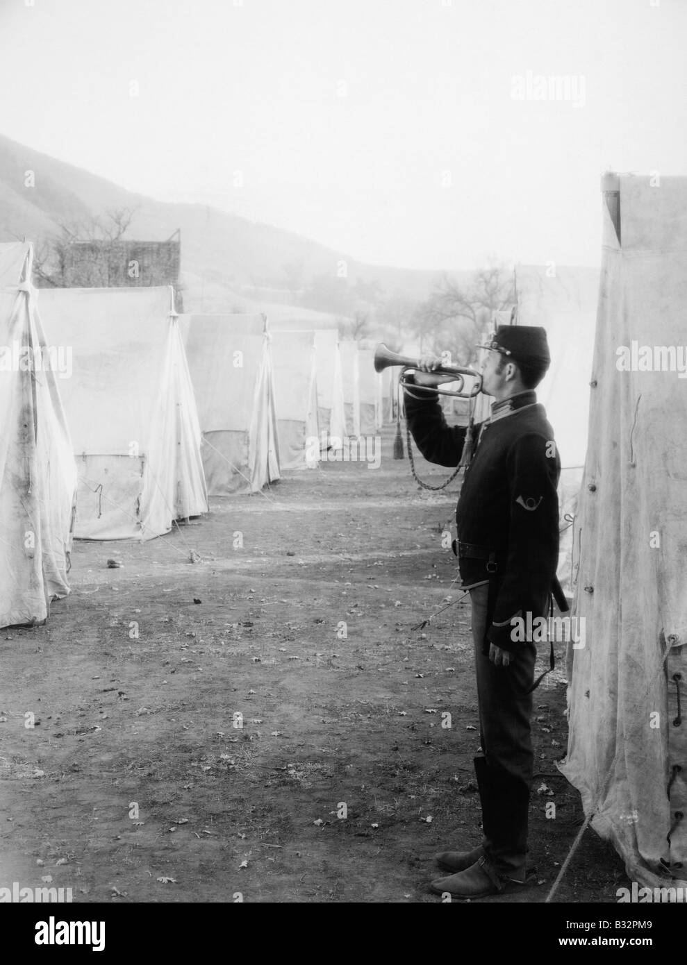 Soldier blowing bugle in army camp Stock Photo