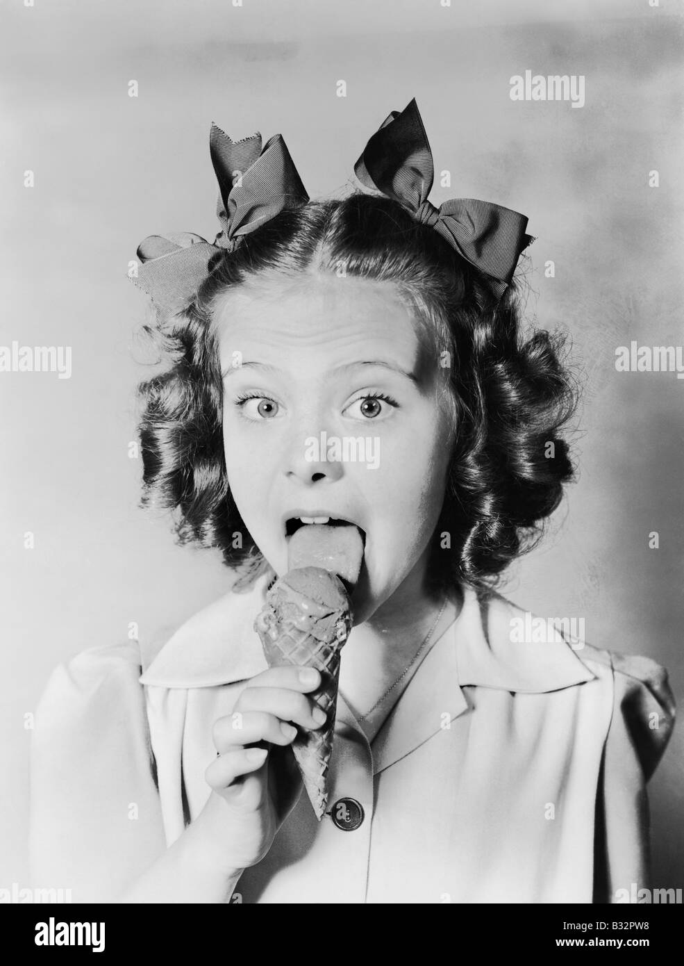 Girl licking ice cream cone Stock Photo