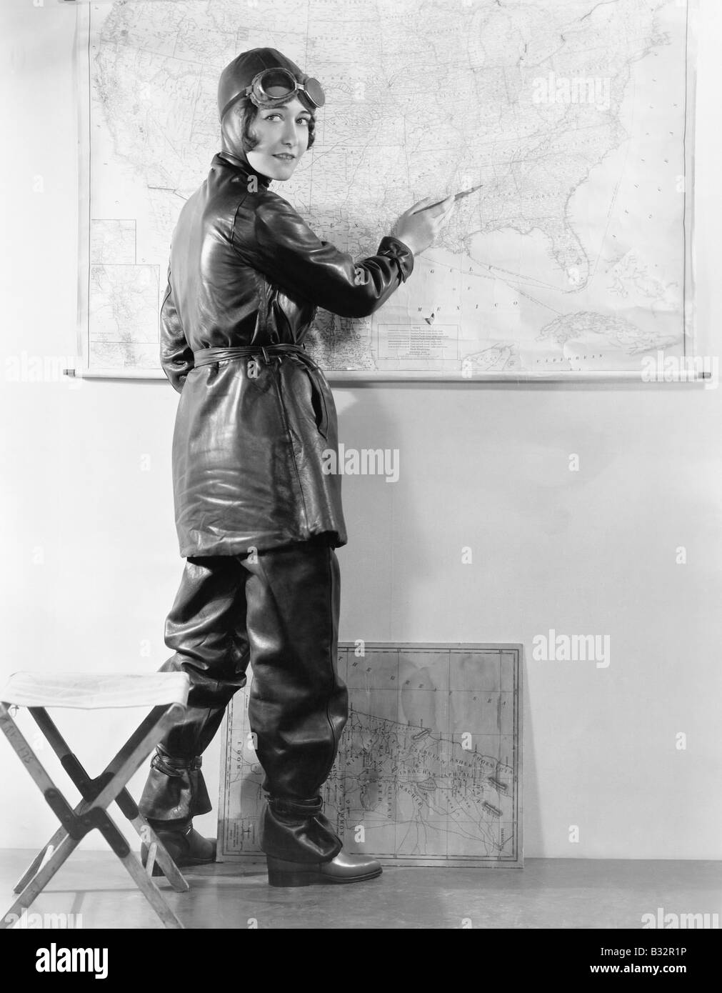 Young woman pointing at a map in a motorcycle outfit Stock Photo