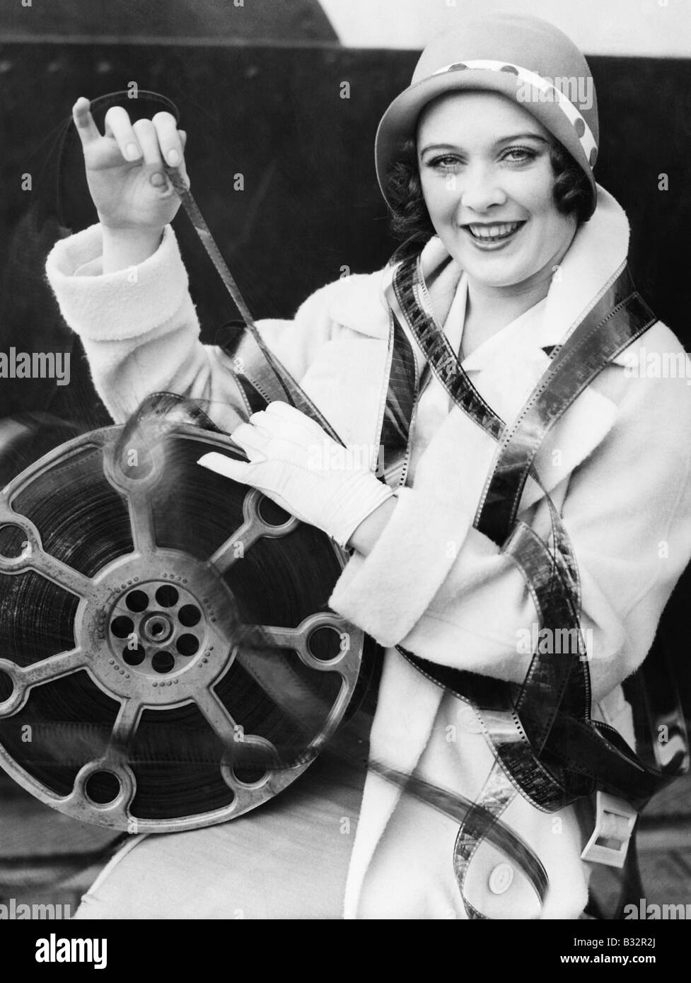 Young woman smiling with film wrapped around her Stock Photo