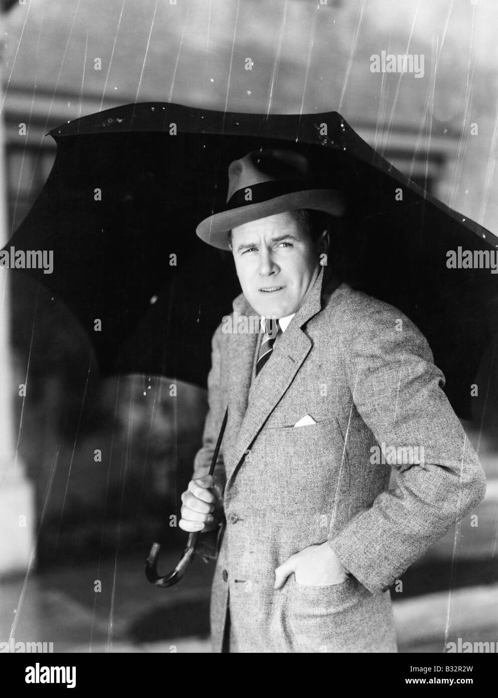 Man with an umbrella standing in the rain Stock Photo
