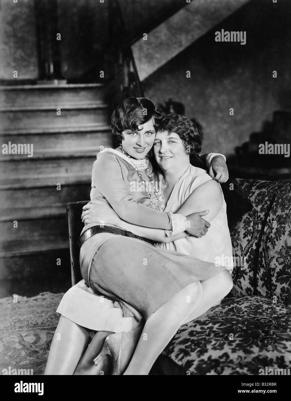 Two women sitting together on the other's lap Stock Photo