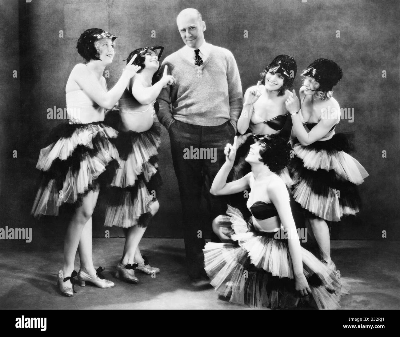 Five young women dancing around a man Stock Photo