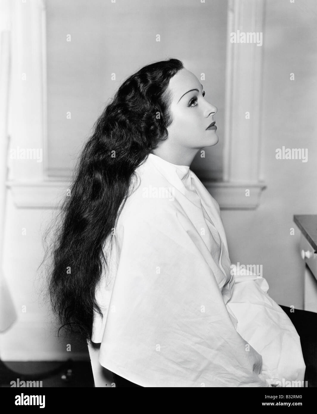 Profile of a young woman sitting in a hair salon with very long hair Stock Photo