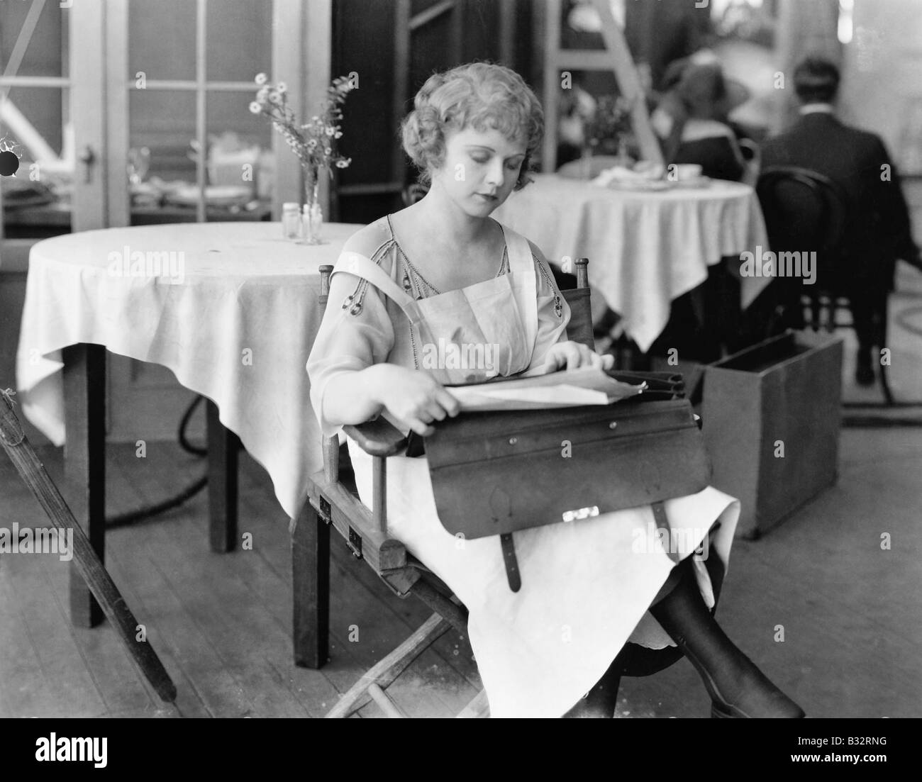 Young woman sitting on a chair and reading documents Stock Photo - Alamy
