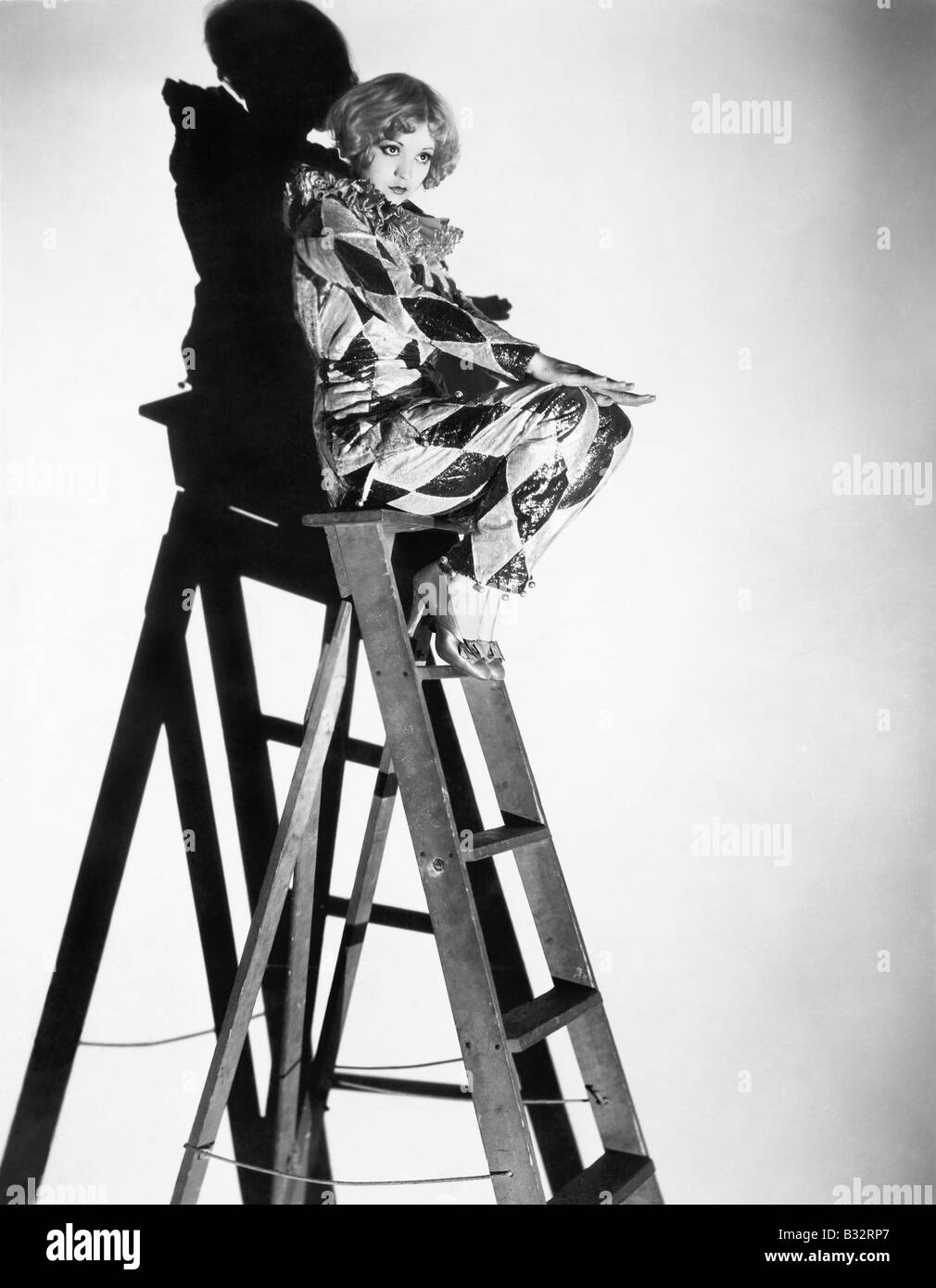Profile of a young woman sitting on a ladder Stock Photo