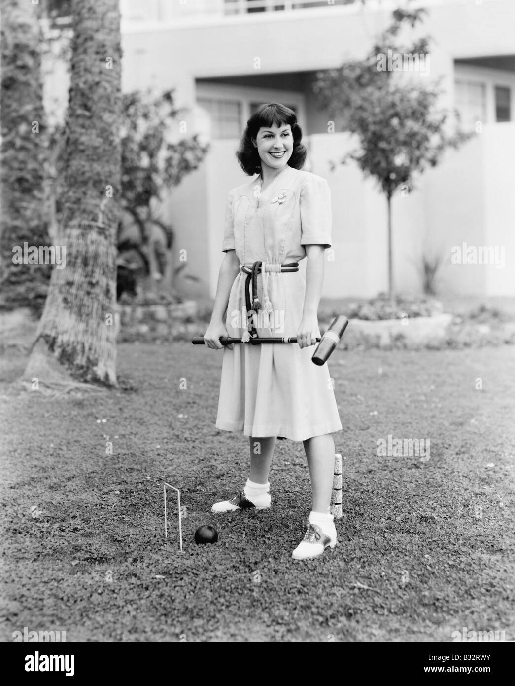 Woman playing croquet in the yard Stock Photo