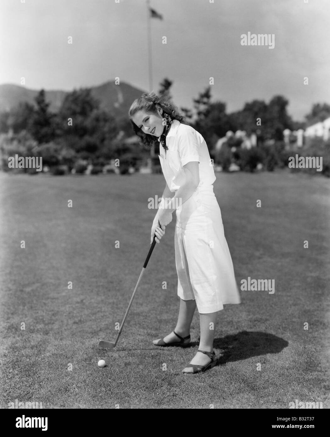 Woman playing golf on a golf course Stock Photo