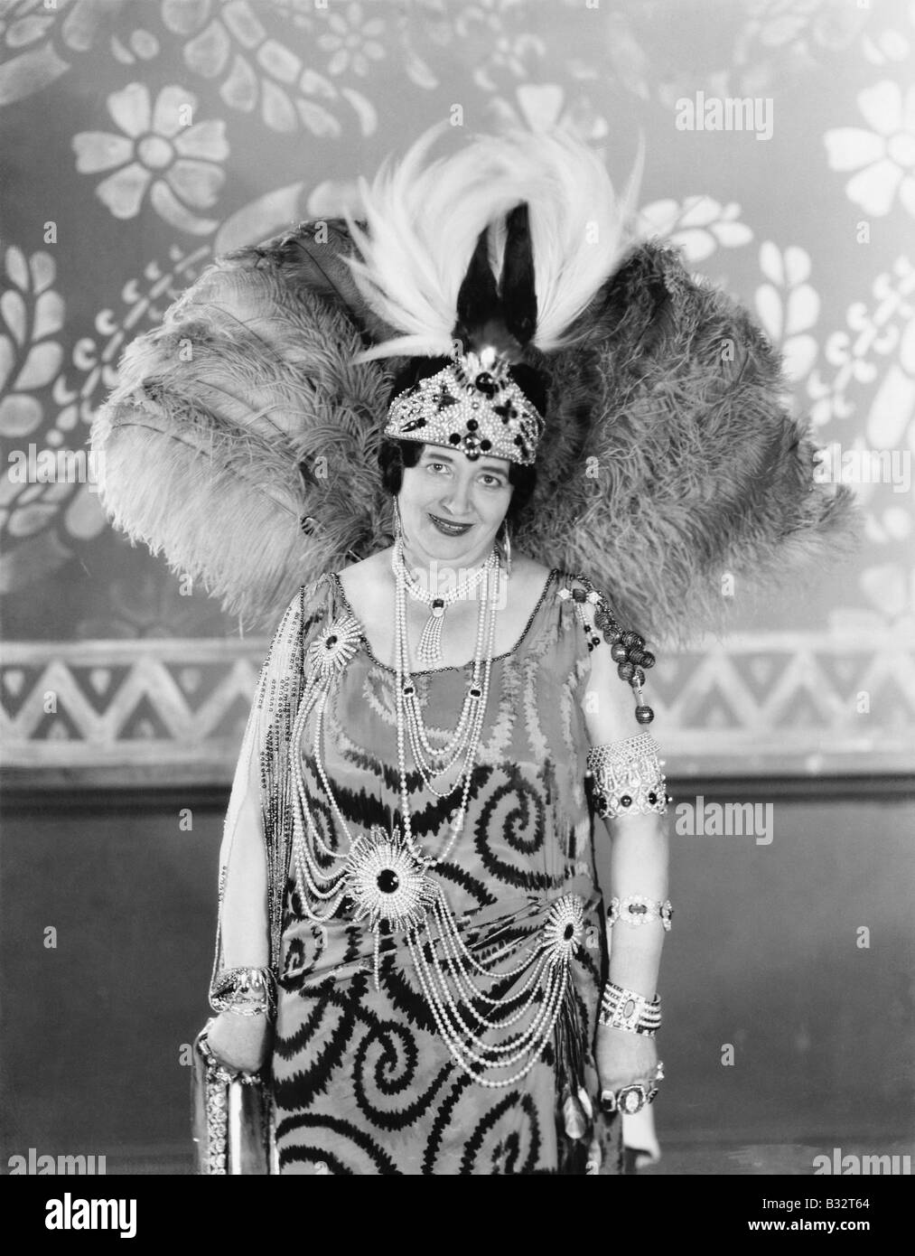 Portrait of a woman smiling wearing a big feather hat Stock Photo - Alamy