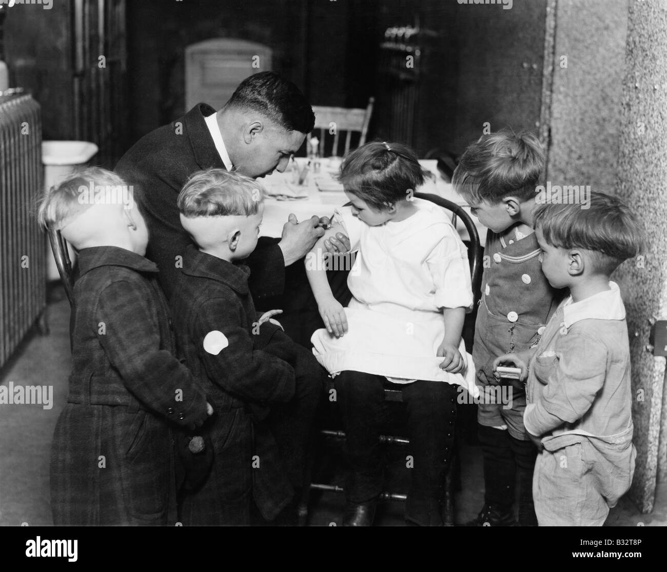 Pediatrician immunizing a little girl while other children are watching ...