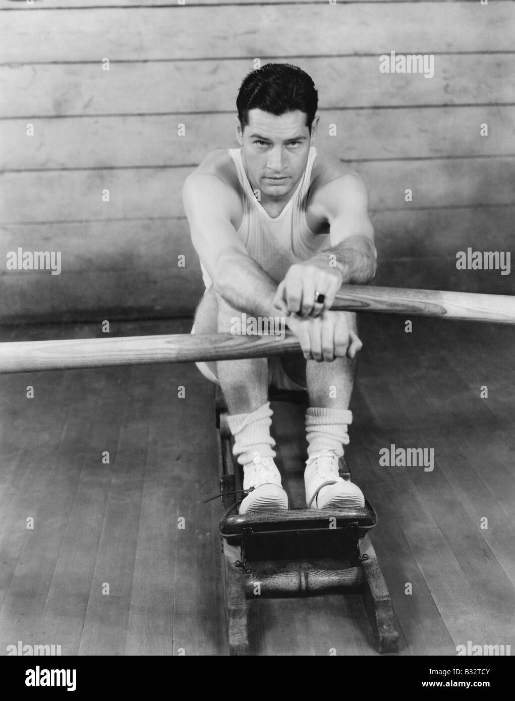 Portrait of a young man exercising on a rowing machine Stock Photo