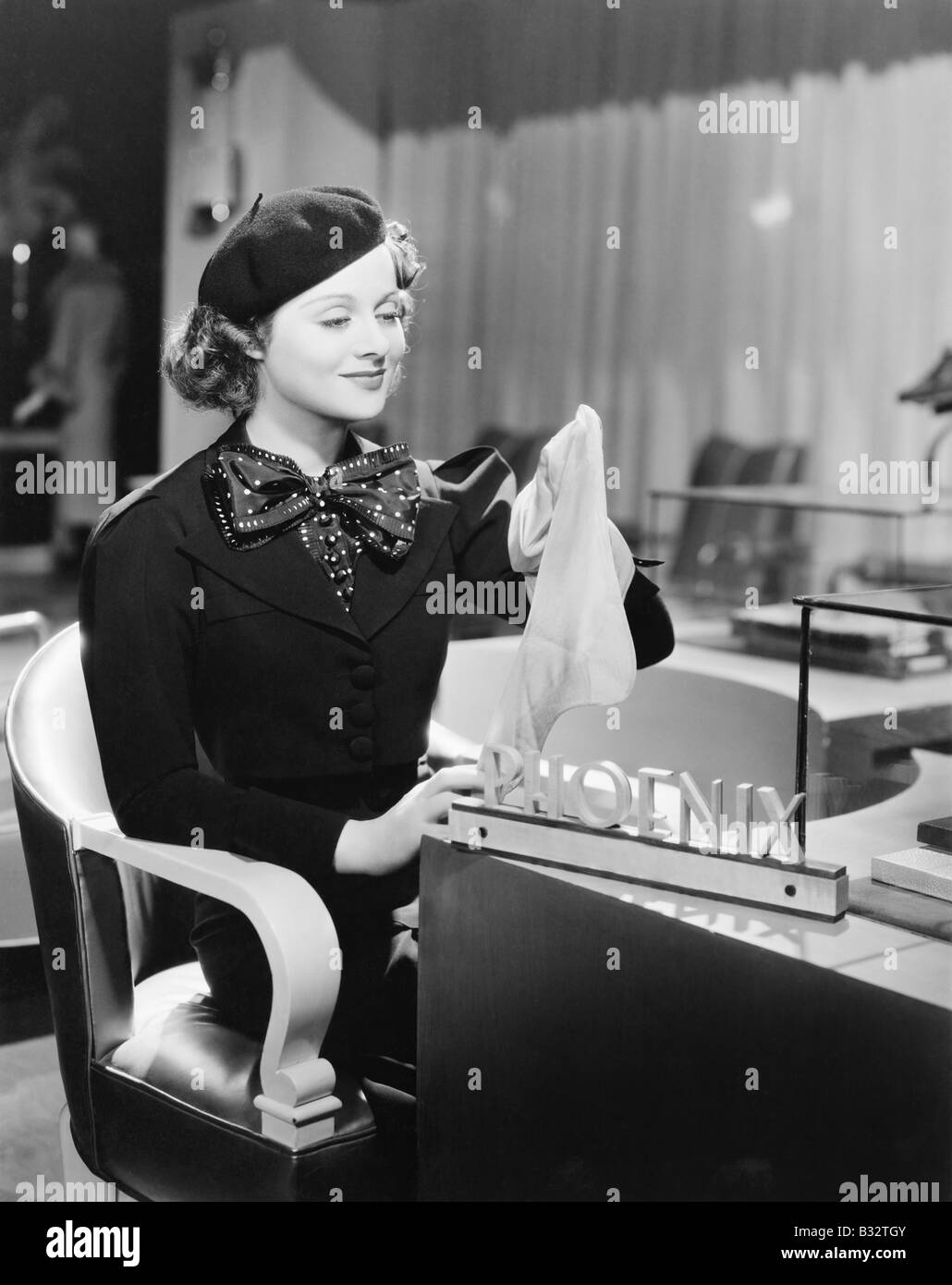 Young woman sitting in a department store and holding stockings Stock