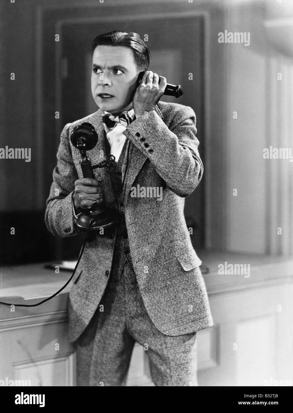 мужчина говорит по стационарному телефону. разговор по старинному телефону. человек со старинным телефоном. молодой мужчина разговаривает по телефону. человек говорит по старому телефону.