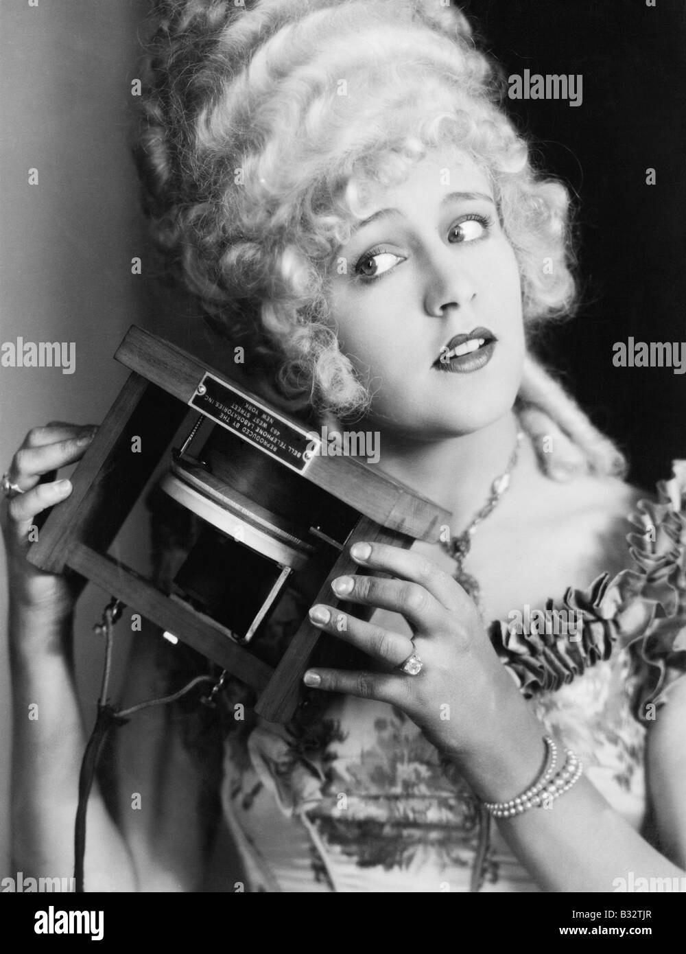 Portrait of a young woman holding one of the first telephones Stock Photo