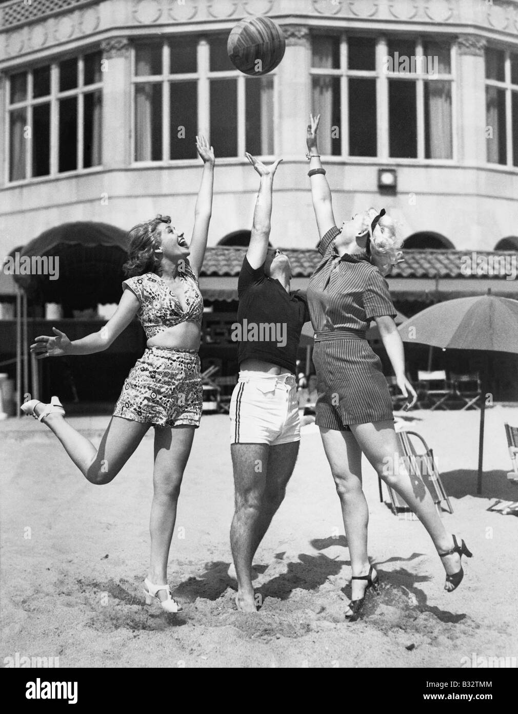 Three young women playing with a ball on the beach Stock Photo