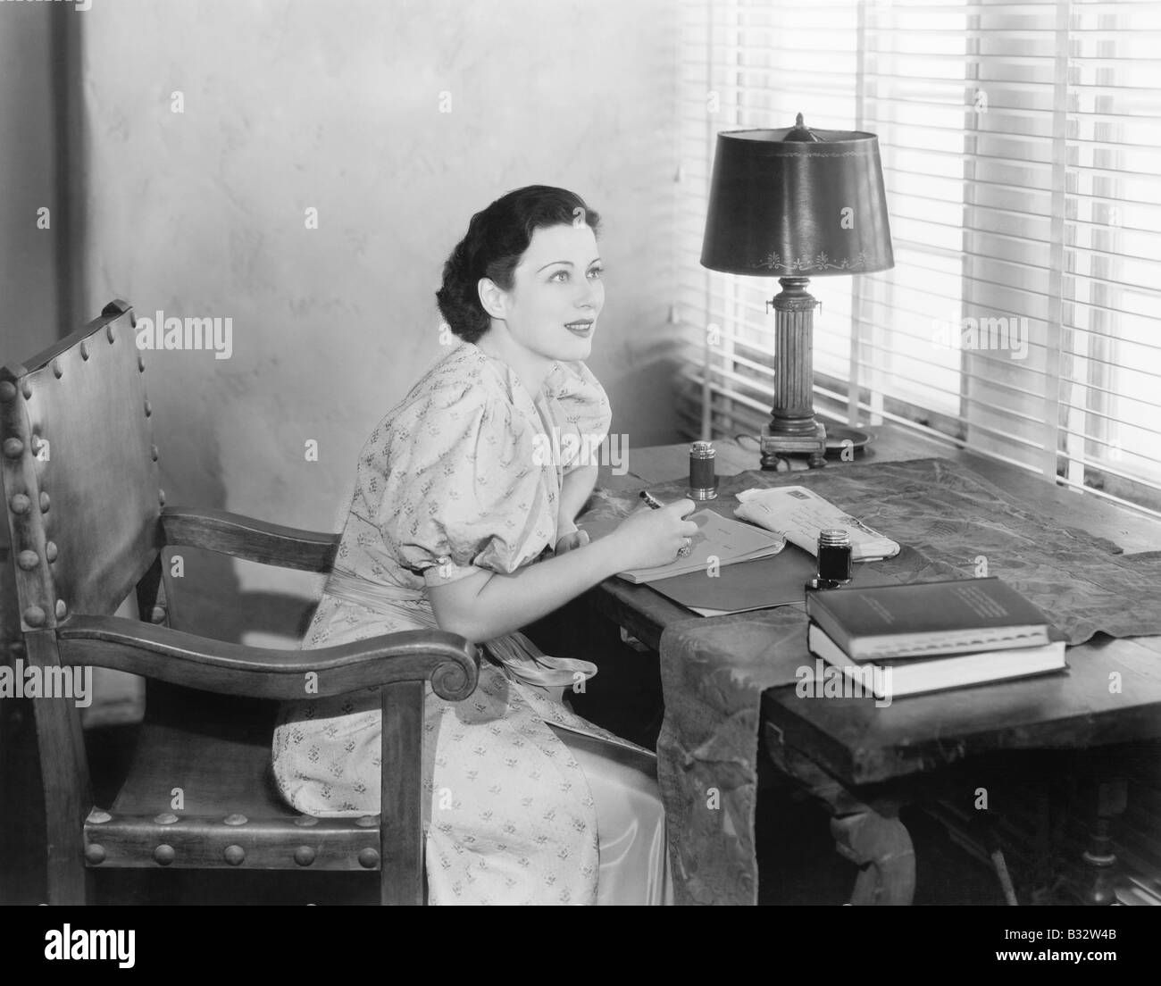 Young woman sitting at her desk writing a letter Stock Photo Alamy
