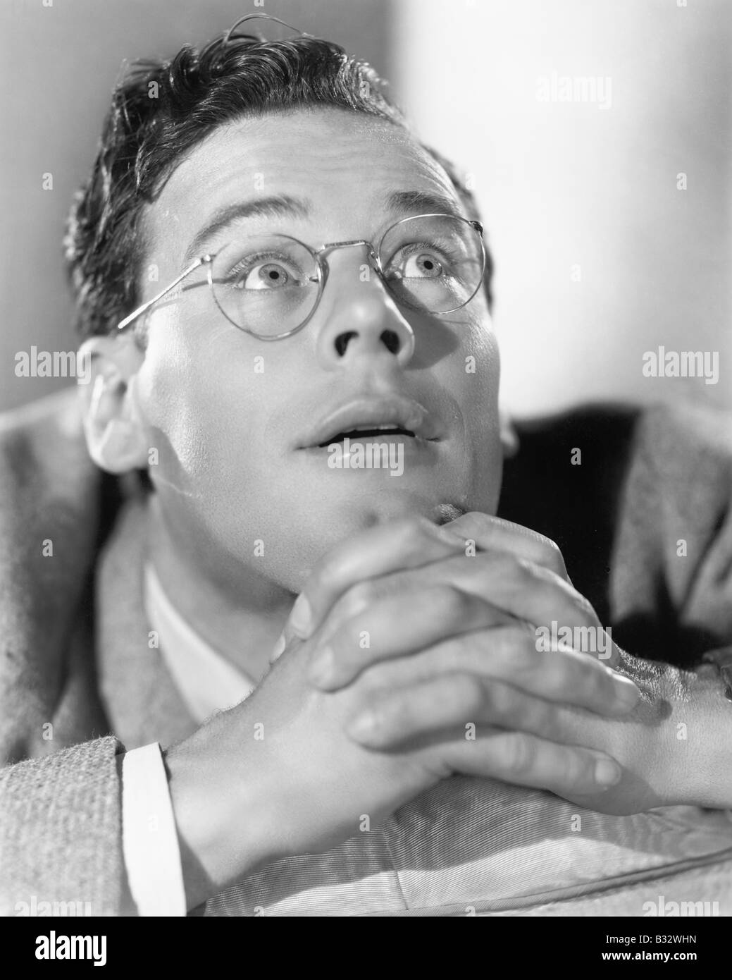 Man with clasped hands looking to the heavens Stock Photo