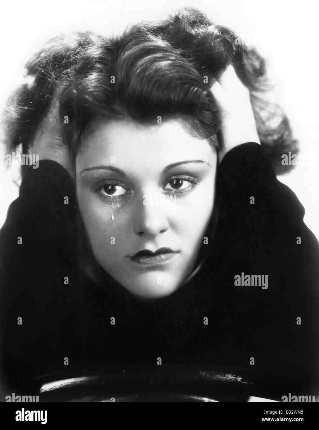 Young woman crying and holding her head in her hands Stock Photo - Alamy
