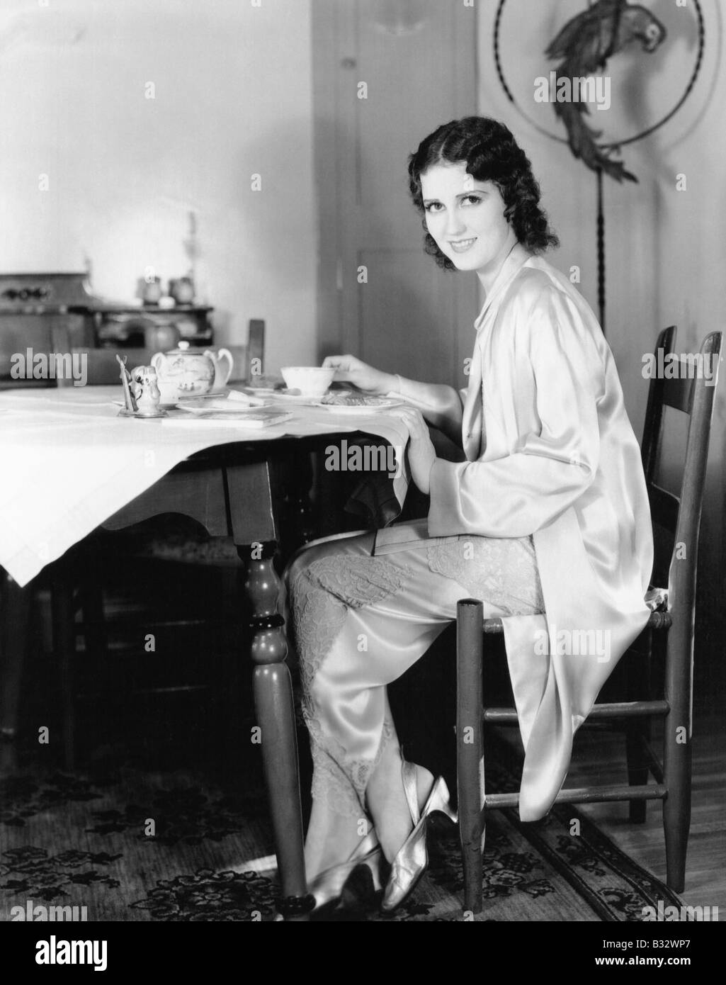 Young woman sitting at table having breakfast tea Stock Photo