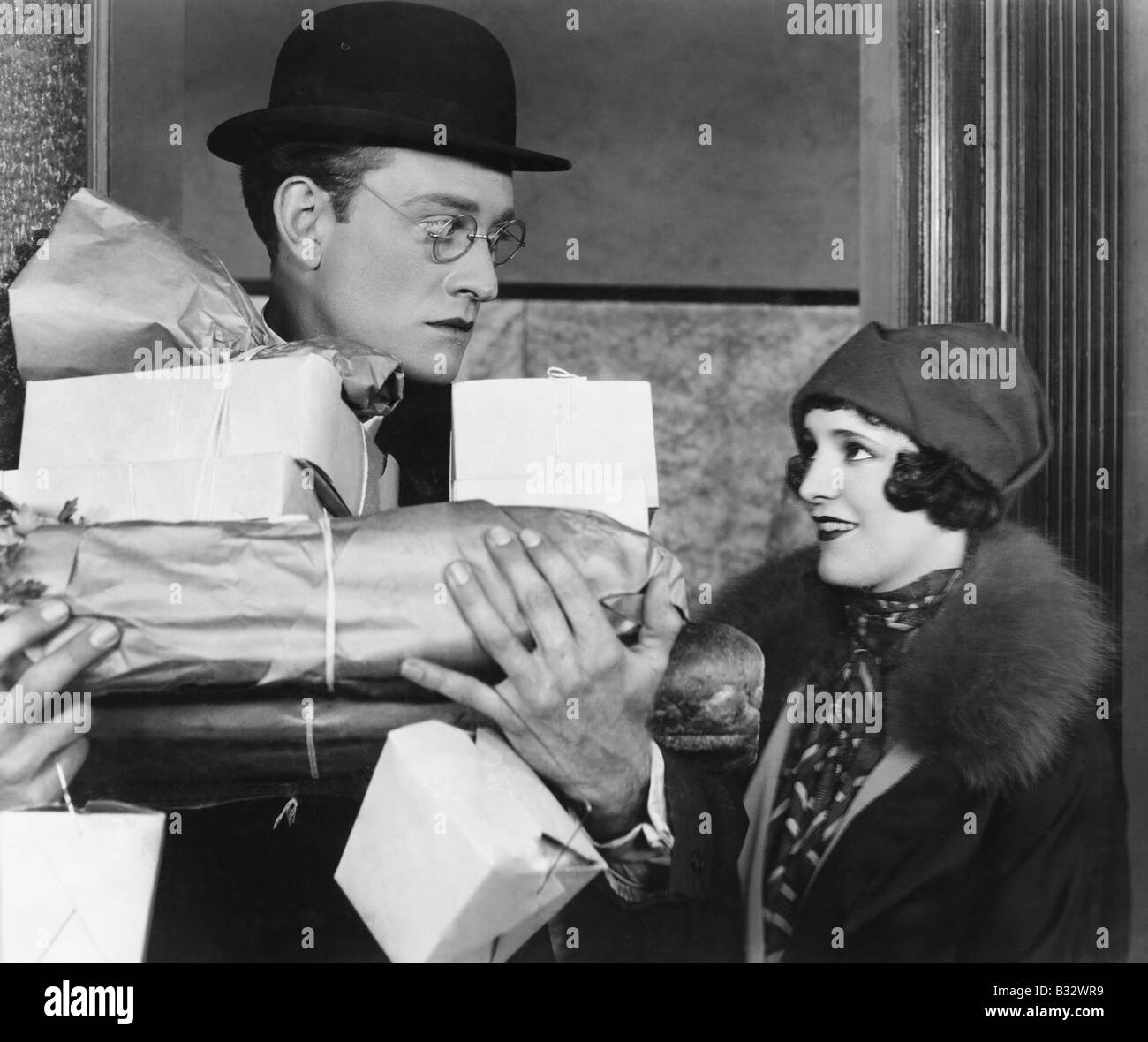 Man with food in his arms looking at a woman Stock Photo