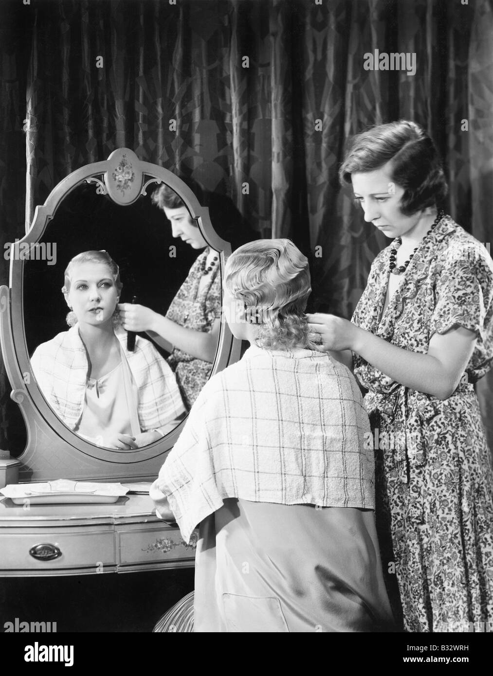 One woman doing an other woman's hair Stock Photo