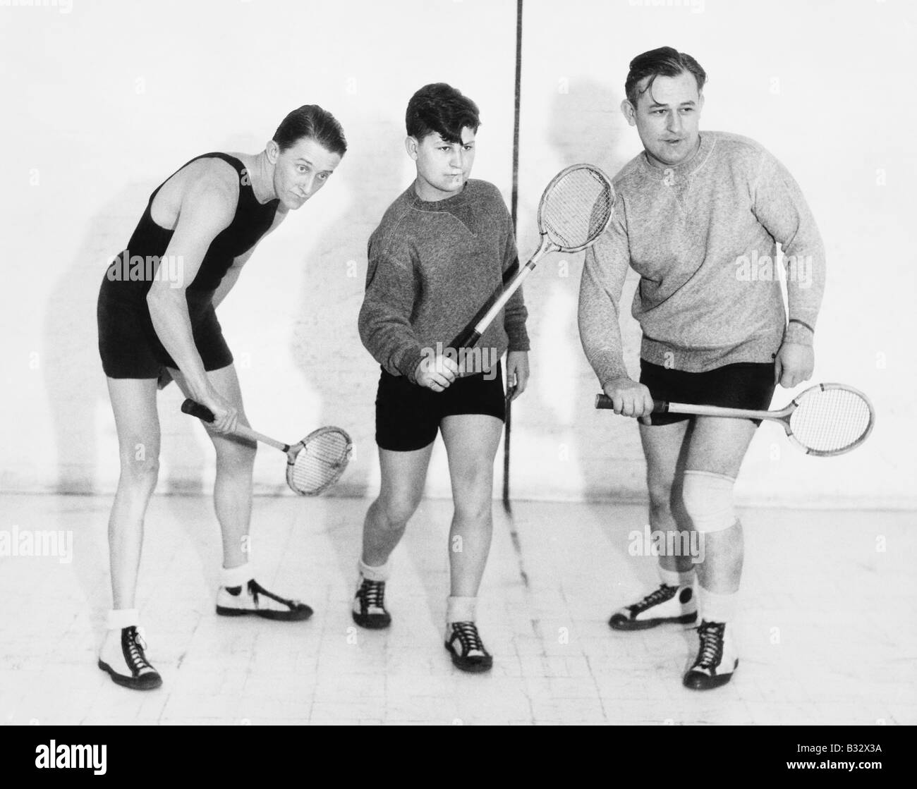 Three men playing squash Stock Photo