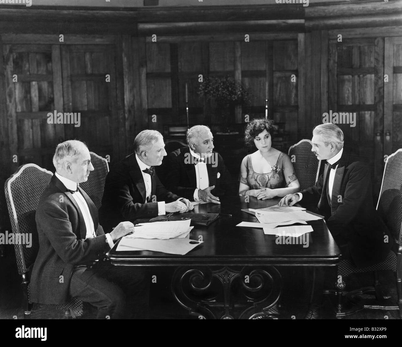 Group of men sitting with a young woman in a boardroom Stock Photo