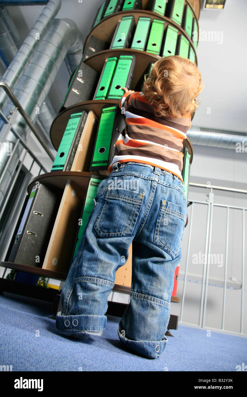 small boy in front of a folder storage rack in the office Stock Photo