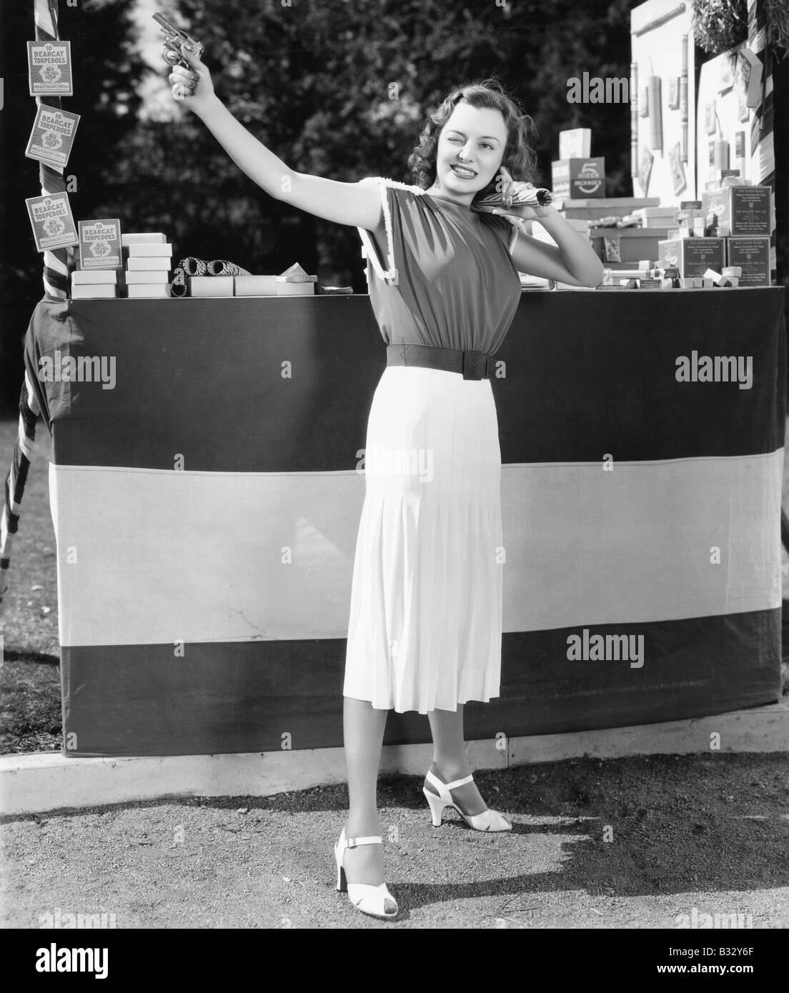 Woman shooting a gun into the air Stock Photo