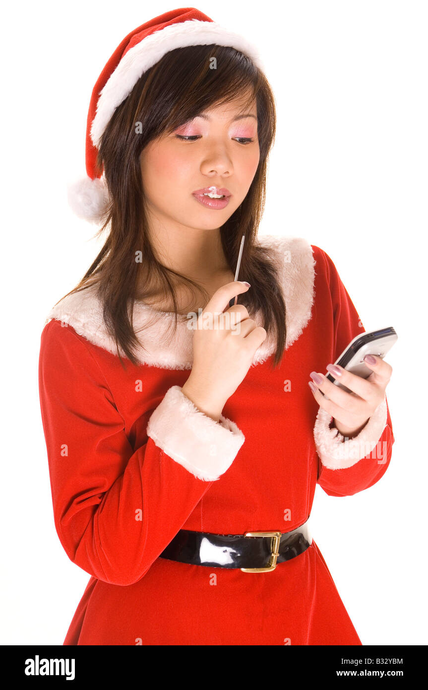 A Cute Asian Girl Dressed As Santa Checks Her List On A Personal 
